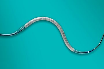 A photograph of an absorbable stent on a blue background