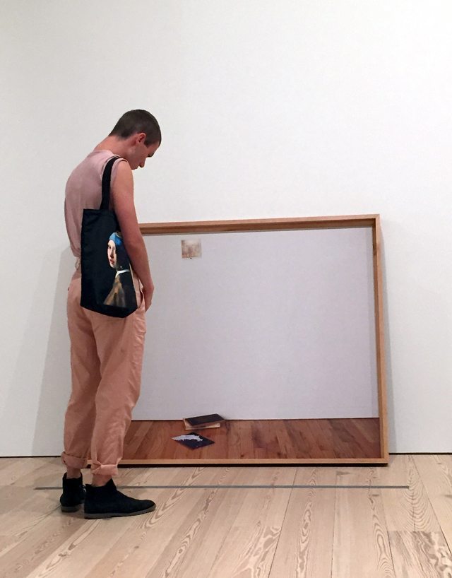Photo of man looking at artwork in a museum