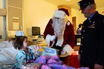 Santa Claus and a firefighter visiting a pediatric patient