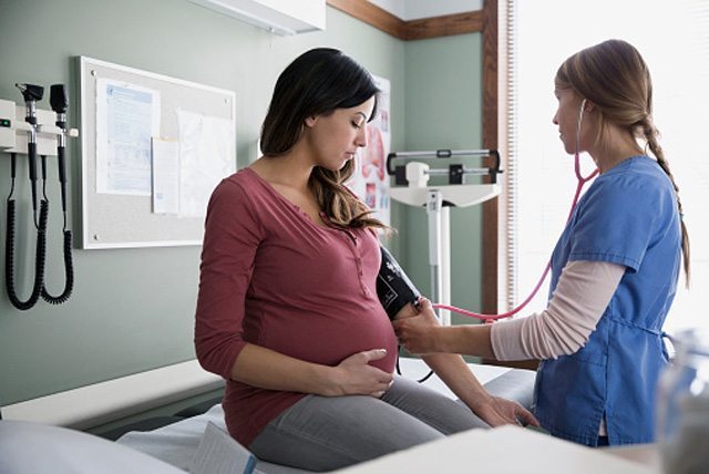 A pregnant woman having her blood pressure taken