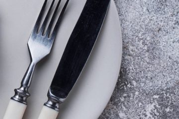 A knife, fork and clock on a plate