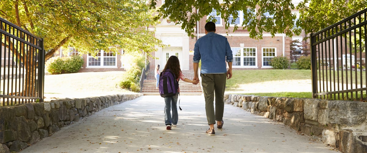 A father and daughter walking to school