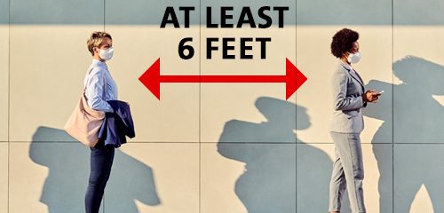 People practicing social distancing outside a building.