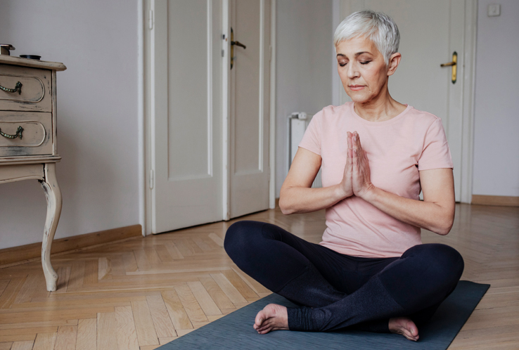 An older woman meditating, one way to help boost your immune system.