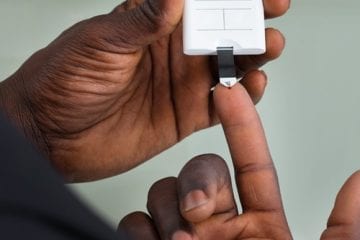 A person with diabetes uses a device to check blood sugar