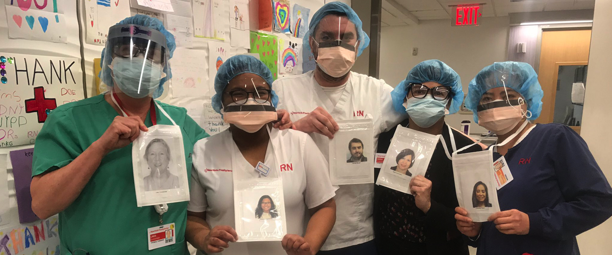 Clinical staff wearing masks hold photos of themselves