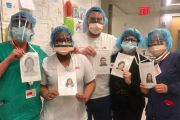 Clinical staff wearing masks hold photos of themselves