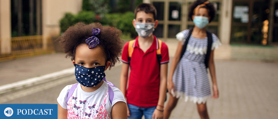Children wearing masks outside a school.