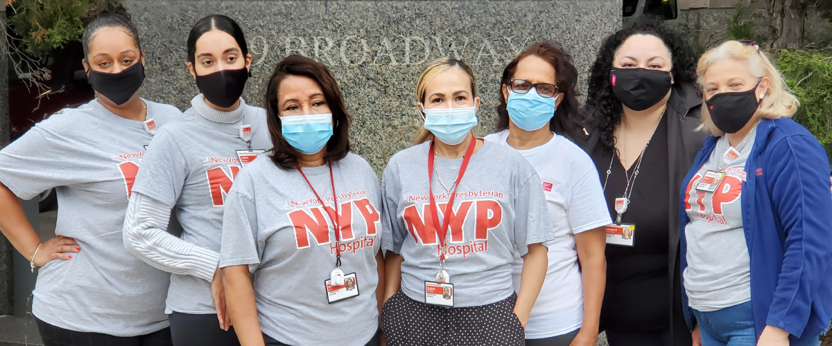 Community Health Workers stand with NYP shirts and surgical face masks