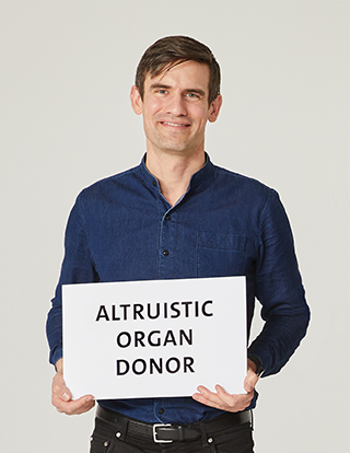 Living kidney donor Hendrik Gerrits holding a sign that says "altruistic organ donor."