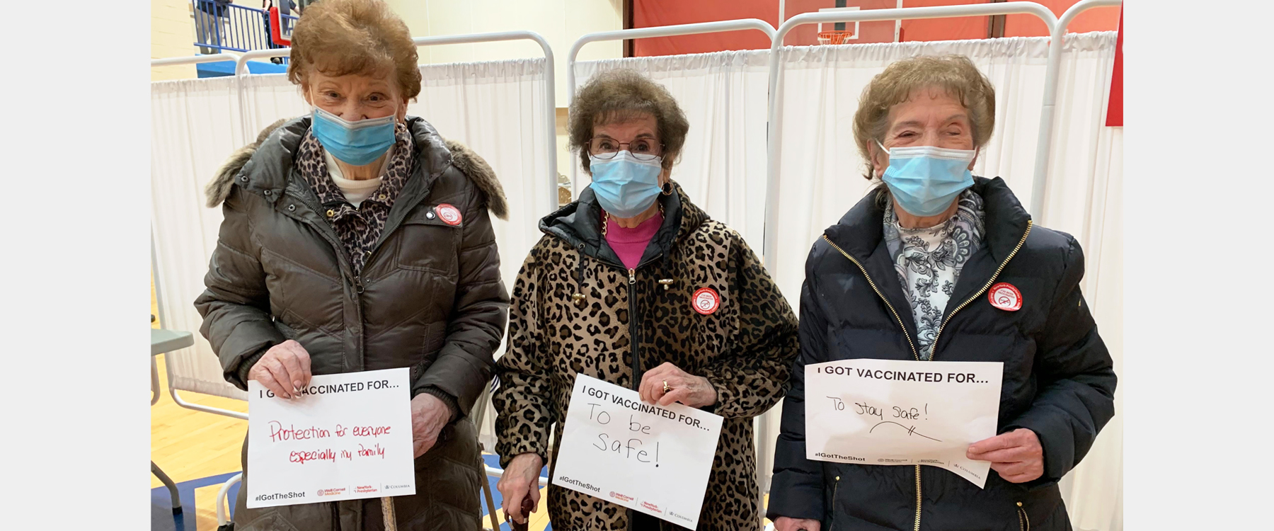Three senior women holding signs saying why they got their vaccine