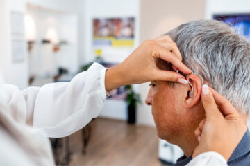 A man with hearing loss getting a hearing aid