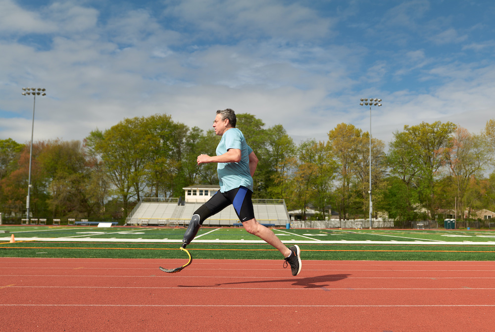 Image of Gary Yerman, after a leg amputation, running on a track.
