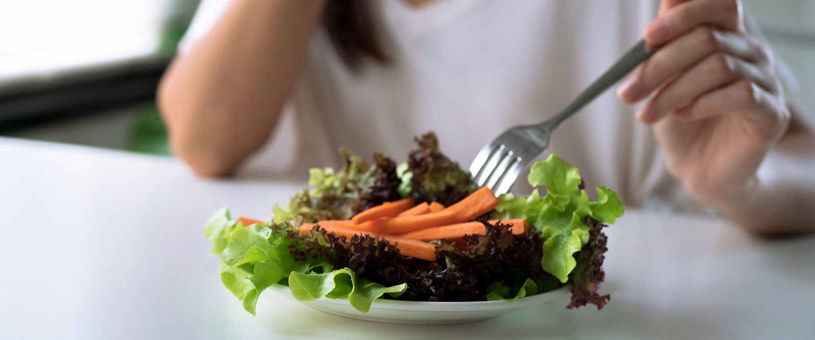 Woman with disordered eating picking at salad