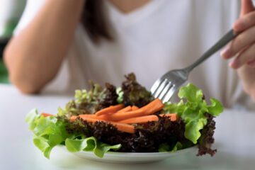 Woman with disordered eating picking at salad
