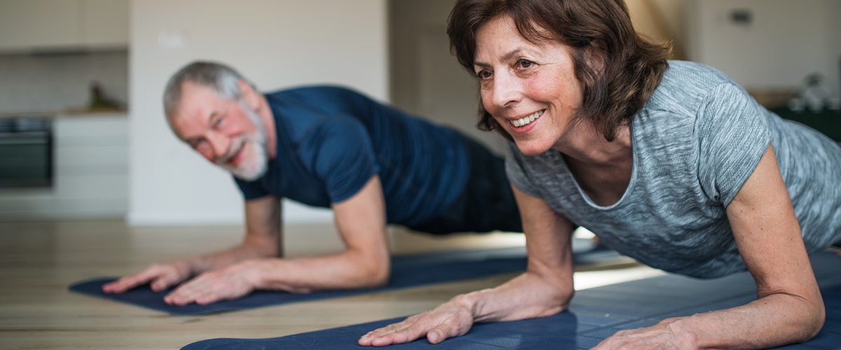 Two older people in a plank position