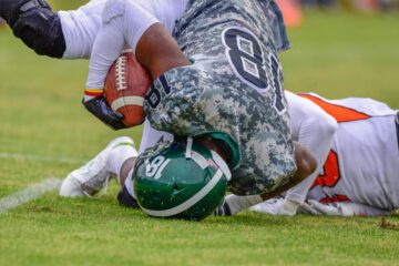 Young football player hits his head on the ground after being tackled. These head injuries could lead to CTE.