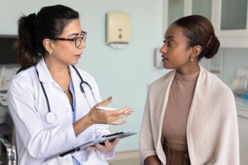A doctor speaking with a patient in a doctor's office.