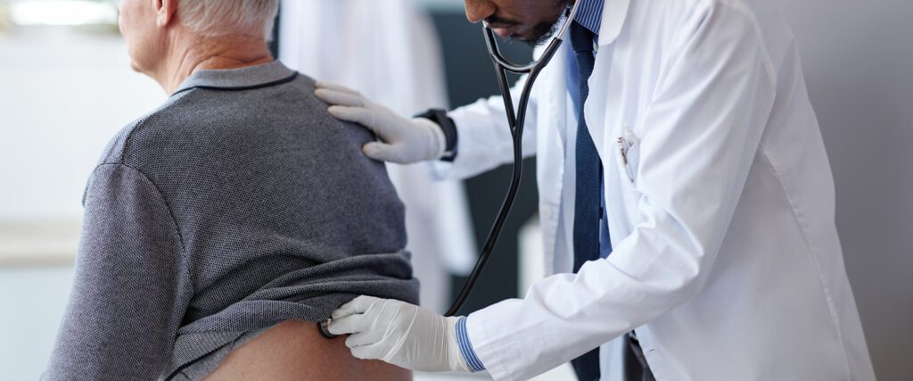 A doctor listens to a patient's lungs.