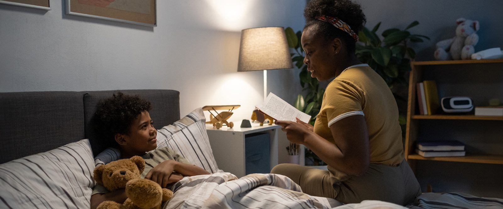 A parent reads a bedtime story to a child as part of their sleep schedule.