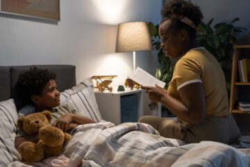 A parent reads a bedtime story to a child as part of their sleep schedule.