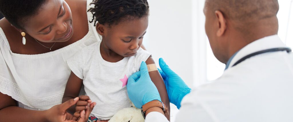 A mom holding a child after a vaccine.