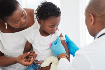 A mom holding a child after a vaccine.