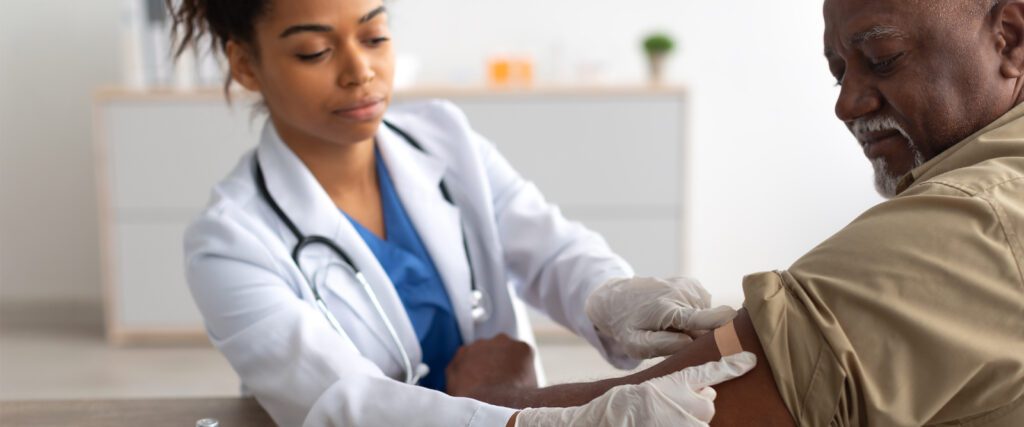 A man receiving a shot from a nurse.