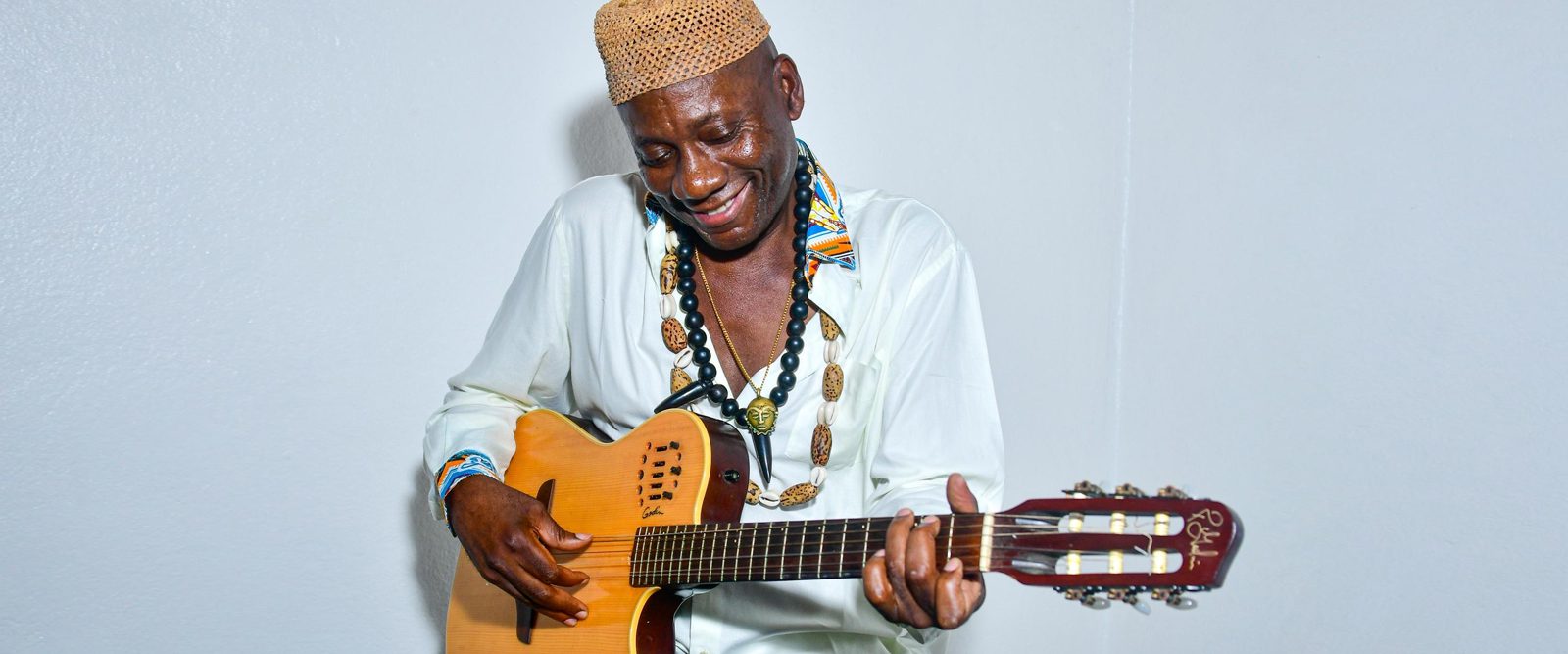 Francis Mbappe, who received a liver transplant at NewYork-Presbyterian, sitting with his bass guitar.