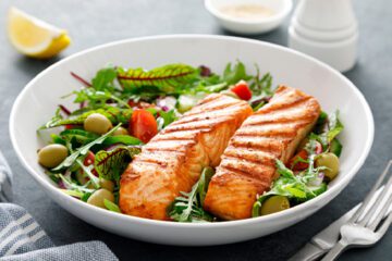 plate of salmon over salad