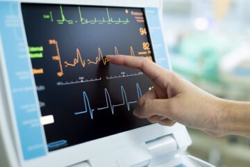 A doctor looking at a heart rate on a monitor